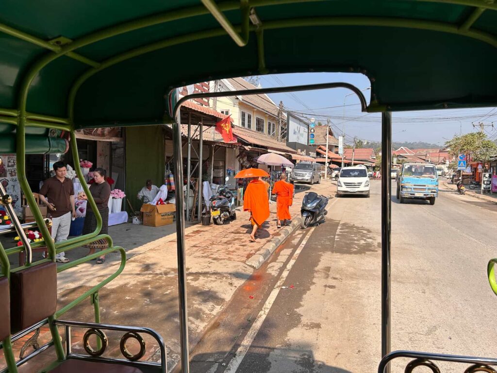 spacerujący mnisi ulicami Luang Prabang. Luang Prabang z dziećmi
