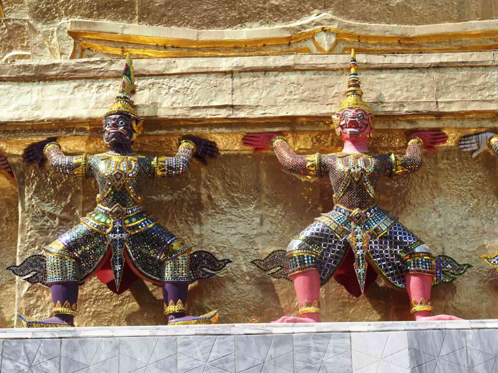 Kolorowi strażnicy podtrzymujący Phra Si Rattana Chedi w kompleksie Wat Phra Kaew w Bangkoku.