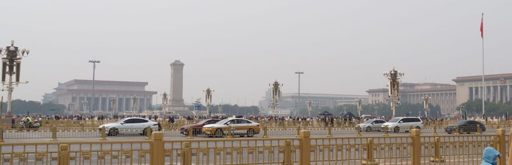 Plac Tiananmen w Pekinie z monumentalną zabudową i ruchem ulicznym